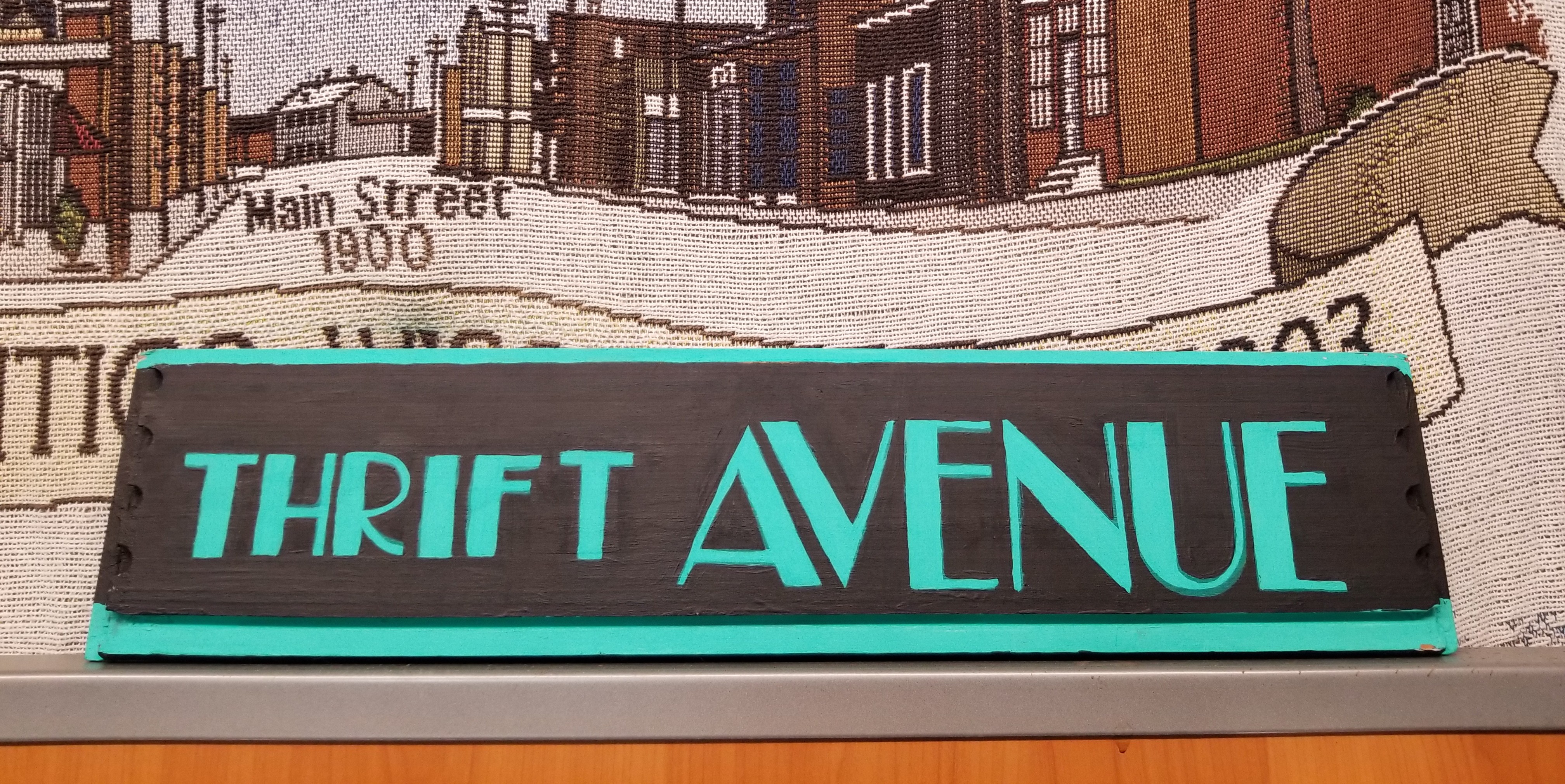 Photo of the Thrift Avenue sign. Handpainted in Teal on a Black background, Broadway font