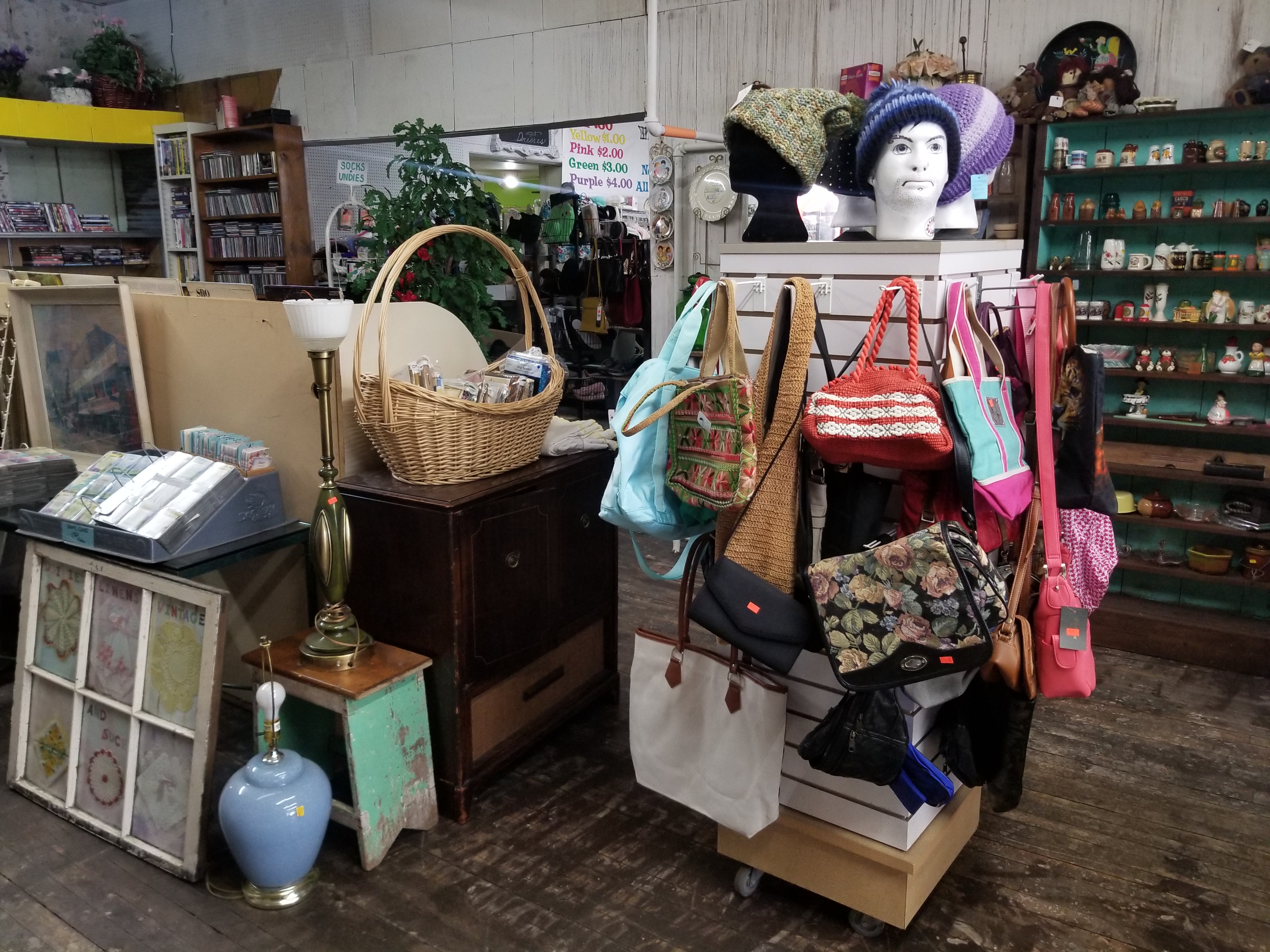 Photo of a display near the register, featuring handbags, name cards, vinyl records, and a wall of vintage salt shakers.