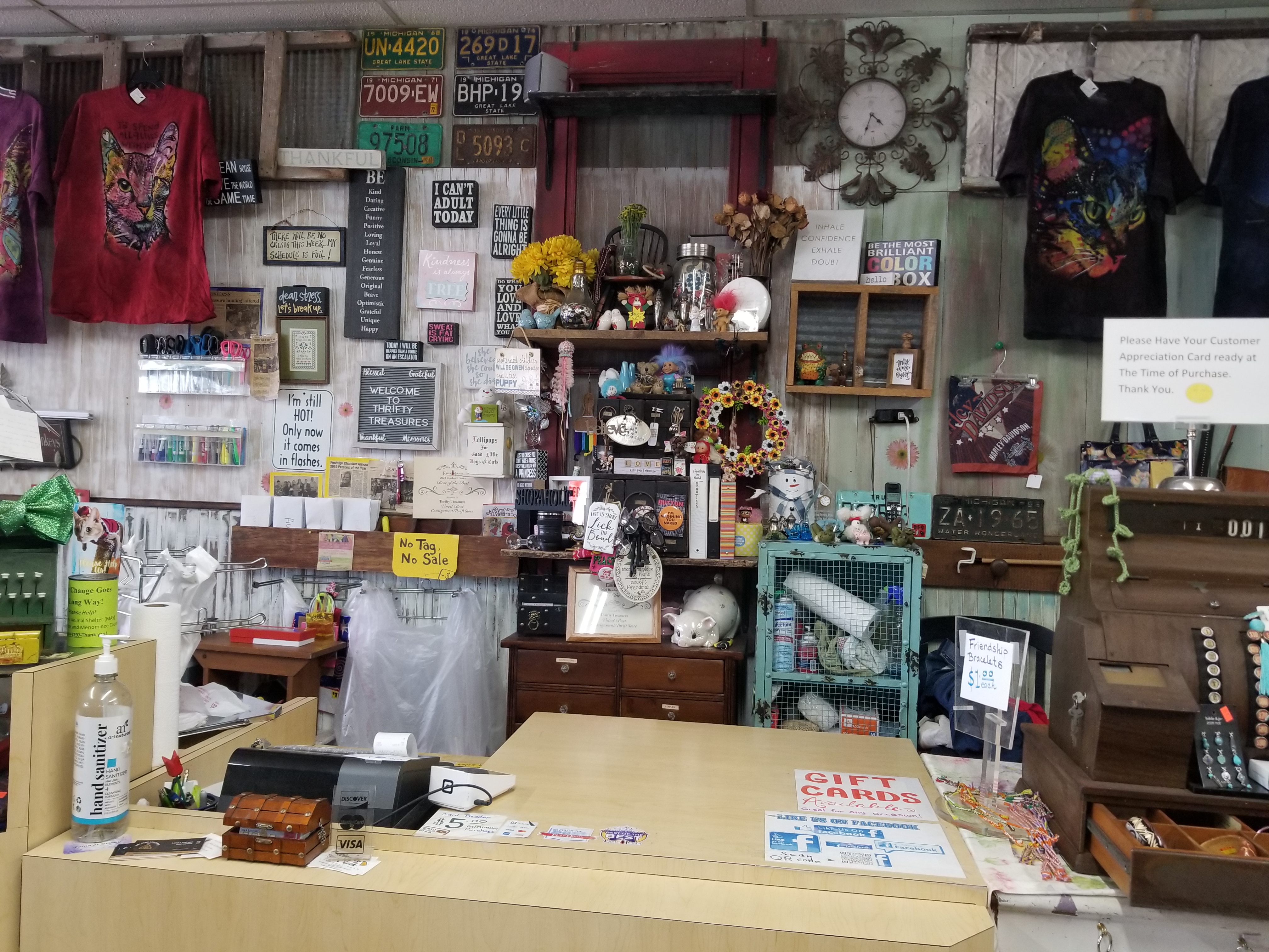 Photo of a customer's view of the cash register, cute photos signs and tchotchkis in the background.
